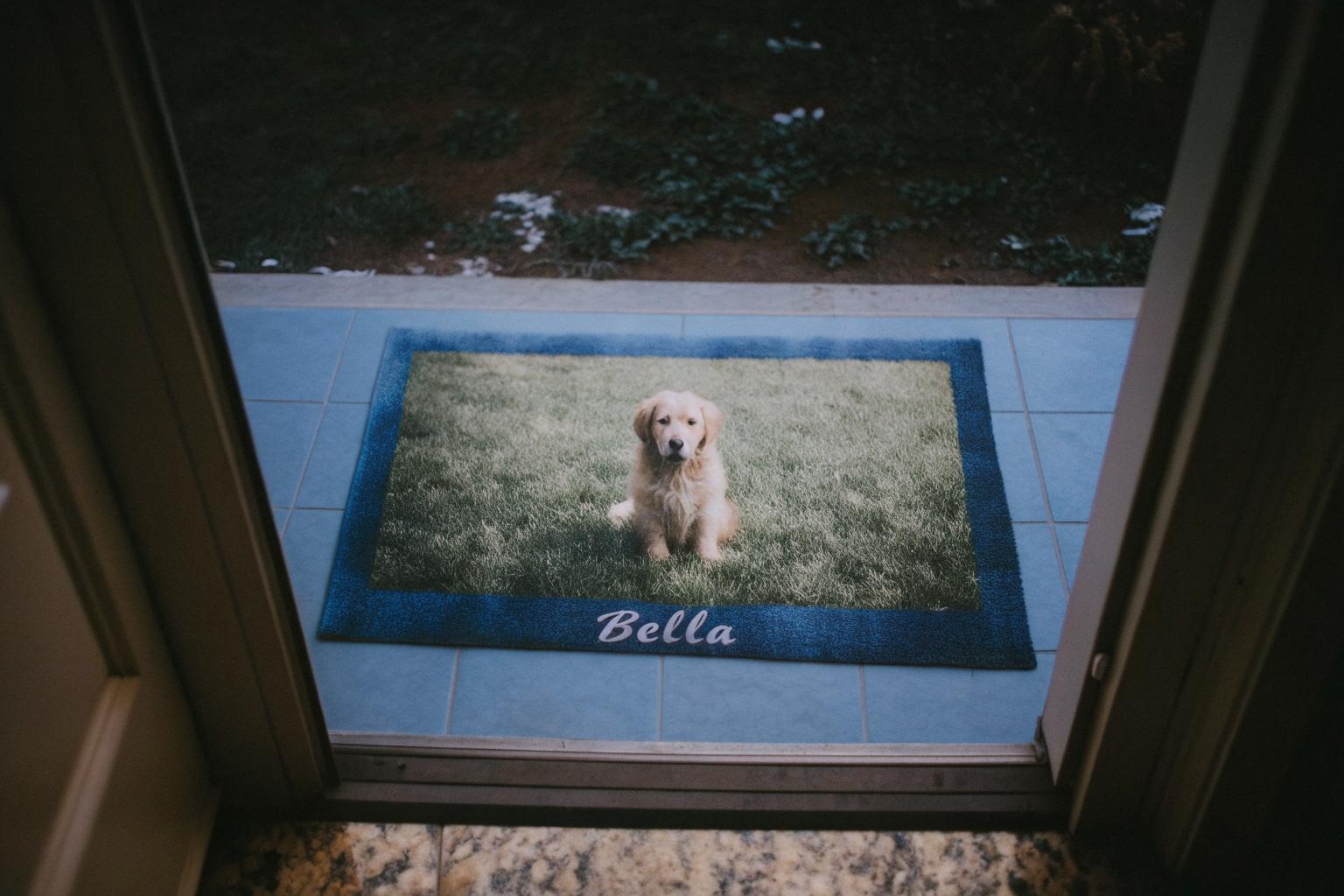 Personalized photo bath mat featuring a custom pet portrait, shown by a front door